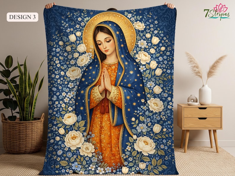 May include: A blue blanket featuring a religious illustration of a woman with a gold halo, wearing a blue cloak and orange dress. The blanket is decorated with white flowers and the text "DESIGN 3".