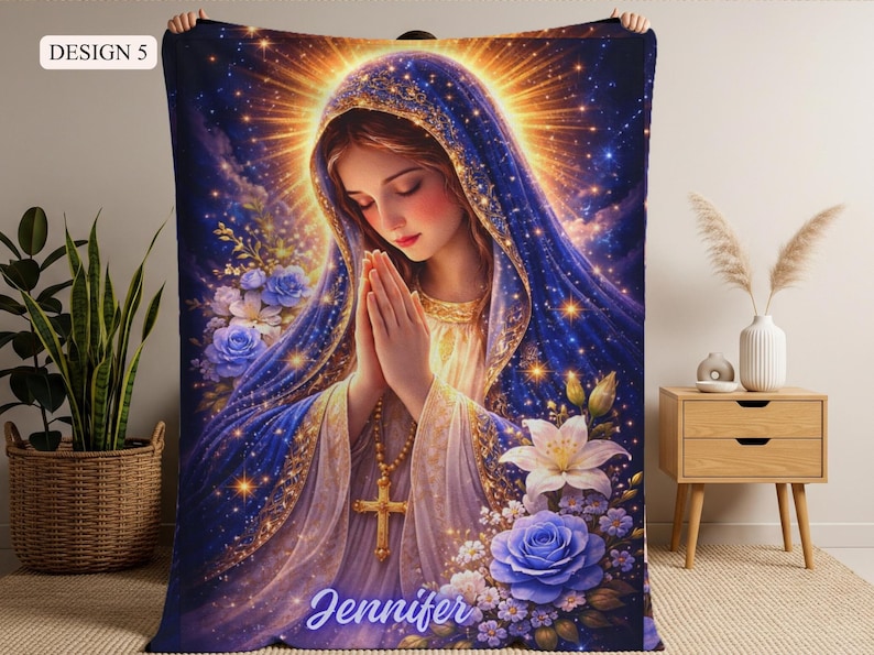 May include: A plush blanket featuring a serene illustration of a woman in prayer, adorned with a blue veil and gold accents. The design includes blue roses, white lilies, and the name "Jennifer". The blanket has a celestial theme.