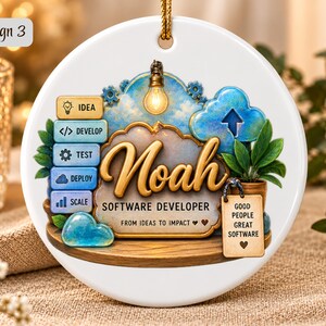 Może przedstawiać: Okrągła biała ceramiczna ozdoba z imieniem Noah oraz tekstem Software Developer, From Ideas to Impact i Good People Great Software. Wz&oacute;r zawiera stos pięciu niebiesko-ż&oacute;łtych ikon, żar&oacute;wkę oraz roślinę.