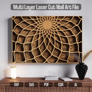 Puede incluir: Archivo de arte mural cortado con láser multicapa. La obra de arte presenta un diseño detallado y en capas con un patrón central de explosión solar. La pieza está hecha de madera de color marrón claro y es rectangular. El texto "Multi Layer Laser Cut Wall Art File" está en la parte superior.