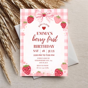 Puede incluir: Una invitación rosa y blanca con temática de fresas. El texto dice "Emma's berry first birthday" con la fecha, hora y lugar. El diseño incluye fresas, un lazo y un estampado de cuadros vichy.