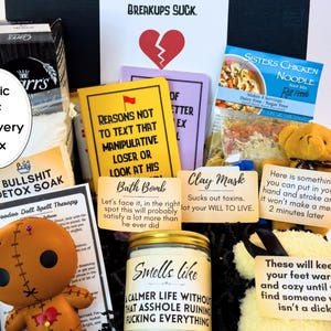 Puede incluir: Una caja de regalo "Toxic MF Recovery Box" llena de varios art&iacute;culos. Incluye una mu&ntilde;eca vud&uacute;, una bomba de ba&ntilde;o, una mascarilla de arcilla, una vela y un osito de peluche que sostiene un letrero. La caja est&aacute; dise&ntilde;ada para ayudar a recuperarse de una ruptura.