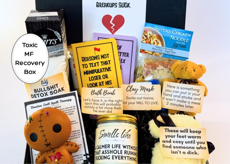 Puede incluir: Una caja de regalo "Toxic MF Recovery Box" llena de varios art&iacute;culos. Incluye una mu&ntilde;eca vud&uacute;, una bomba de ba&ntilde;o, una mascarilla de arcilla, una vela y un osito de peluche que sostiene un letrero. La caja est&aacute; dise&ntilde;ada para ayudar a recuperarse de una ruptura.