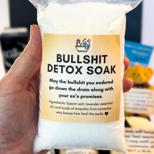 Puede incluir: Una bolsa de pl&aacute;stico transparente llena de sales de ba&ntilde;o blancas. La bolsa tiene una etiqueta amarilla con el texto "BULLSHIT DETOX SOAK". La etiqueta tambi&eacute;n incluye el texto "May the bullshit you endured go down the drain along with your ex's promises."