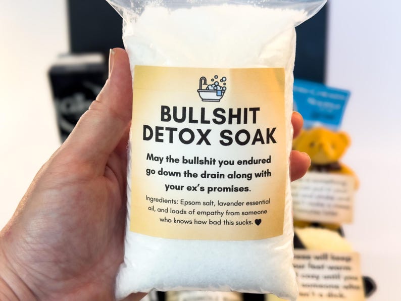 Puede incluir: Una bolsa de pl&aacute;stico transparente llena de sales de ba&ntilde;o blancas. La bolsa tiene una etiqueta amarilla con el texto "BULLSHIT DETOX SOAK". La etiqueta tambi&eacute;n incluye el texto "May the bullshit you endured go down the drain along with your ex's promises."