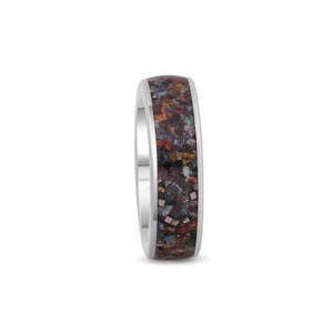 May include: A silver band ring with a dark brown inlay featuring a variety of colorful flecks and specks.