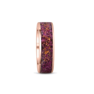 Könnte beinhalten: Ein Roségold-Bandring mit einer violetten und goldenen Einlage. Die Einlage besteht aus zerkleinerten Edelsteinen.