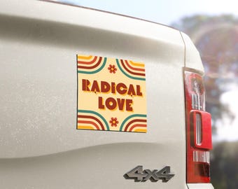 Może przedstawiać: Kwadratowy magnes z napisem "RADICAL LOVE" w stylu retro. Magnes ma kremowe tło z tęczowymi łukami i kwiatowymi akcentami. Jest przymocowany do tyłu białego pojazdu.