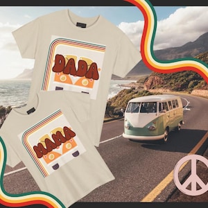 Könnte beinhalten: Zwei beige T-Shirts mit Retro-Grafiken. Eines zeigt "DADA" und das andere "MAMA" in braunen Buchstaben über einem orange-weißen Van-Design. Ein grün-weißer Van fährt auf einer Straße mit einem Friedenszeichen.