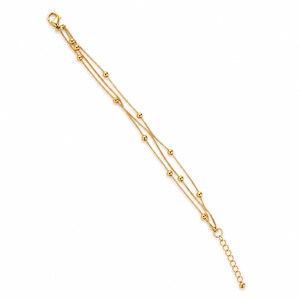 K&ouml;nnte beinhalten: Ein goldfarbenes mehrstr&auml;ngiges Armband mit drei feinen Ketten, die mit kleinen, gleichm&auml;&szlig;ig verteilten goldenen Kugeln verziert sind. Das Armband verf&uuml;gt &uuml;ber einen Karabinerverschluss an einem Ende und eine verstellbare Verl&auml;ngerungskette.