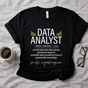 May include: Black t-shirt with the text "DATA ANALYST" and a definition. The definition humorously describes a data analyst as someone who does precise guesswork based on unreliable data. Includes the words "wizard, magician."