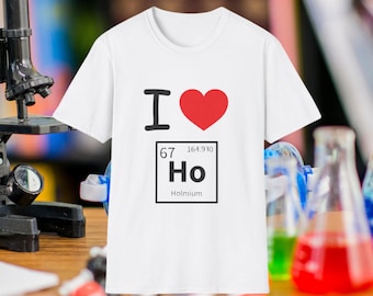 May include: White t-shirt with the text "I ❤️ Ho" and a graphic of the element Holmium. The design features a black "I", a red heart, and the element symbol "Ho" with its atomic number and weight.