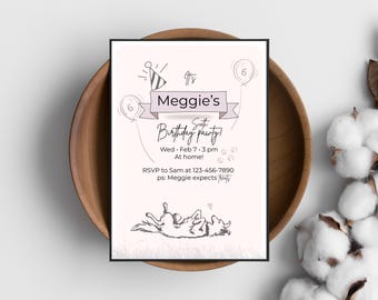 Op de afbeelding: Een lichtroze verjaardagsuitnodiging met zwarte tekst en illustraties. De uitnodiging luidt "Meggie's Zesde Verjaardagsfeestje!" met evenementdetails. De uitnodiging ligt in een houten kom.