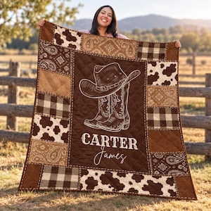 Könnte beinhalten: Eine gesteppte Decke mit einem dunkelbraunen Mittelteil, der eine weiße Strichzeichnung eines Cowboyhutes und Stiefeln sowie den Schriftzug Carter James zeigt. Der Rand besteht aus Patchwork-Quadraten mit Kuhflecken-, Karomuster und Paisleymustern.