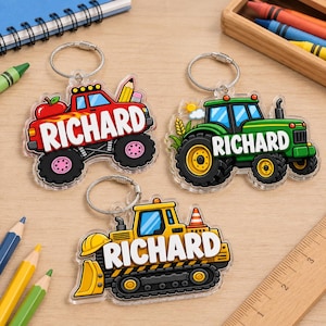 May include: Three acrylic keychains featuring cartoon vehicles: a red monster truck with an apple and pencil, a green tractor with a sun, and a yellow bulldozer with a traffic cone. Each keychain displays the name RICHARD in white block letters.