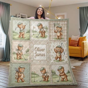 Pode incluir: Um edredom acolchoado com um padrão repetido de ursinhos de desenho animado jogando golfe. Os ursos são retratados em várias poses em um campo de golfe, com o nome "Oliver James" no centro. A paleta de cores inclui verdes, marrons e cremes.