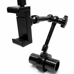 Puede incluir: Un soporte negro ajustable para teléfono con una pinza de resorte para dispositivo móvil, conectado a un brazo articulado de múltiples juntas con perillas de ajuste y una base de abrazadera cilíndrica para fijar a un poste o tubo.