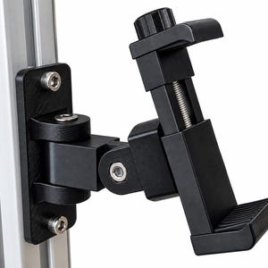 May include: A black adjustable tablet or smartphone mount featuring a spring-loaded clamp mechanism with a textured grip, attached to a silver aluminum extrusion profile via a black mounting plate secured with two visible silver hex bolts.