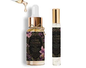 May include: Two glass bottles of ritual oil, one with a dropper and the other a rollerball. The larger bottle has a gold cap and a label with the words "COME CLOSER" and floral illustrations. The smaller bottle has a gold cap and the same label.