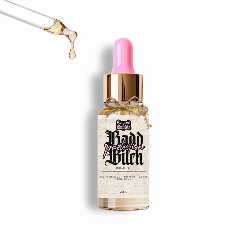 Puede incluir: Una botella de vidrio de aceite ritual con cuentagotas rosa y tapa dorada. La etiqueta dice "Sacred Baddie Kadd Protection Bitch Ritual Oil". Un peque&ntilde;o dije de llave cuelga de la botella. El aceite es de 20 ml.