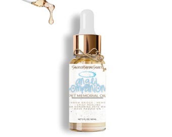 Può includere: Una bottiglia di vetro trasparente con tappo dorato ed etichetta bianca. L'etichetta recita "Angel Companion Pet Memorial Oil". Un contagocce eroga un liquido dorato. La bottiglia è legata con spago e un piccolo ciondolo a forma di chiave.