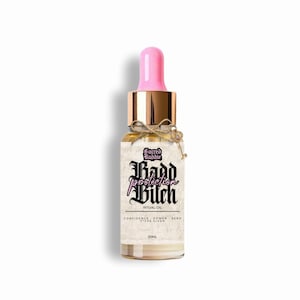 Puede incluir: Una botella de vidrio de aceite ritual con un cuentagotas rosa y tapa dorada. La etiqueta dice "Sacred Baddie, protection Bitch, Ritual Oil". Un peque&ntilde;o dije de llave cuelga de la botella. La botella contiene 20 ml de aceite.