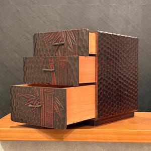 Cassettiera giapponese Kamakura Bori in legno con motivo a bambù, epoca Showa. Altezza 24 cm (9,4 pollici), larghezza 18 cm (7,1 pollici), profondità 22 cm (8,7 pollici). Intagliata a mano e laccata.