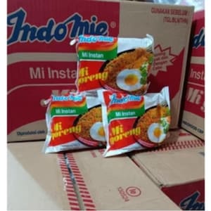 May include: A stack of Indomie Mi Goreng instant noodle packets and boxes. The packets feature images of the noodles with an egg. The boxes are red and white with the Indomie logo.
