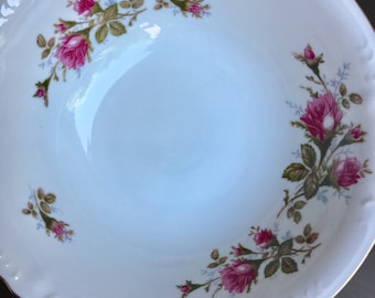 May include: A white ceramic bowl with a gold rim and a floral design featuring pink roses and green leaves.