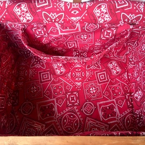 May include: A wooden box with a red and white bandana lining. The box has a hinged lid and a metal chain.