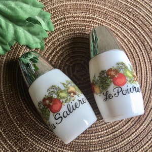 Vintage White Milk Glass Salt and Pepper Shakers. Gemco Spice of Life Salt and Pepper Shaker Set have French inscriptions:  La Saliere and Le Poivrier.
Black cursive lettering on both. Shakers date sometime between 1960 - 1980. My Vintage Alcove.