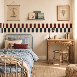 Pode incluir: Um quarto com estrutura de cama de metal azul claro, roupa de cama de xadrez azul e branco, uma manta bege e um urso de peluche. Uma secretária de madeira com cadeira, candeeiro e livros. Parede com padrão de riscas vermelhas e azuis.
