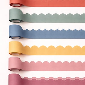 Pode incluir: Seis rolos de borda de papel com acabamento festonado dispostos em uma pilha vertical. As cores de cima para baixo são coral, verde sálvia, azul ardósia, amarelo mostarda, rosa claro e rosa antigo. Cada rolo apresenta um padrão ondulado.