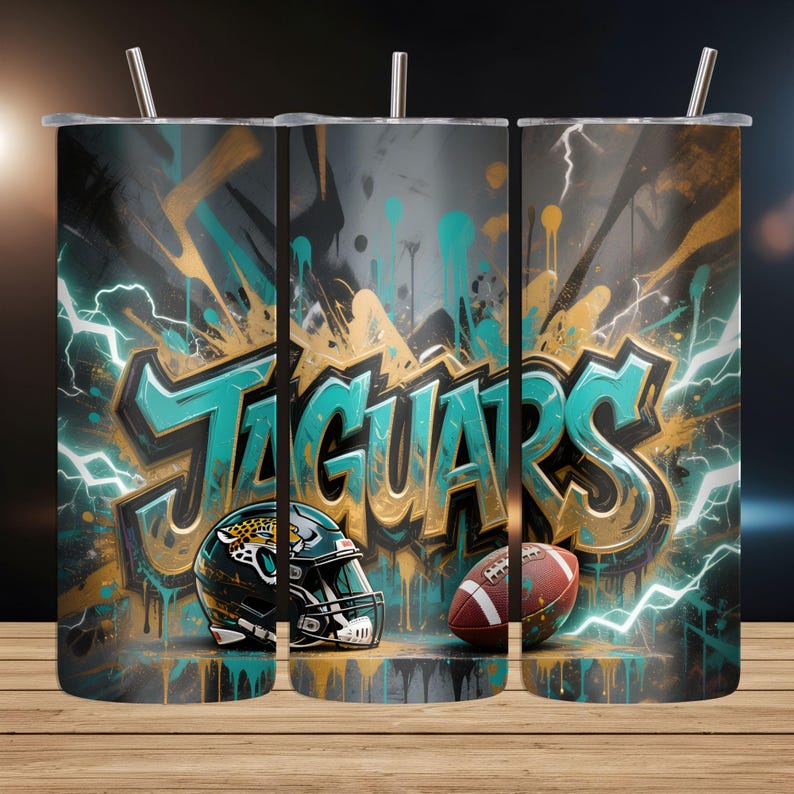 May include: A set of three stainless steel tumblers with lids and straws. Each tumbler features a graffiti-style design with the word "JAGUARS" in teal and gold, along with a football helmet and football. Teal and white lightning bolts and paint drips complete the design.