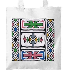 May include: White tote bag with a colorful geometric design. The design features a central rectangular panel with three abstract shapes in green, pink, blue, and yellow. The sides have diamond patterns in various colors. The bag has two white handles.