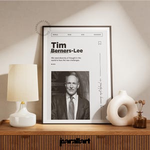 May include: A framed black and white print featuring Tim Berners-Lee. The print includes the text "Tim Berners-Lee" and a quote. A white lamp, a decorative vase, and a small brown bottle are on a wooden surface.