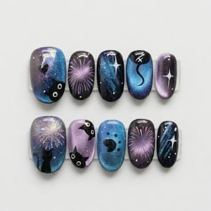 May include: A set of ten oval-shaped false nails with a galaxy-themed design. The nails feature a mix of blue, purple, and black colors with cat and firework illustrations. Some nails have a starry night design.
