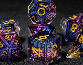May include: A set of polyhedral dice featuring a translucent purple and blue gradient finish with an intricate black web-like cage overlay and embossed gold-colored numbers. The collection includes various geometric shapes used for tabletop gaming.