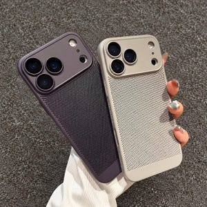 Peut inclure: Deux coques de smartphone, une violet foncé et une beige, présentant une découpe pour triple appareil photo, une ouverture circulaire pour le flash et un panneau arrière en maille micro-perforée texturée sur la surface.