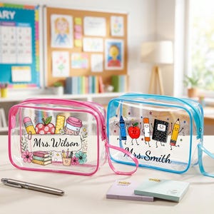Puede incluir: Dos estuches rectangulares de vinilo transparente con cremallera y correa de mu&ntilde;eca. El estuche izquierdo tiene un borde rosa y un gr&aacute;fico de &uacute;tiles escolares con el texto Mrs. Wilson. El derecho tiene un borde azul y un gr&aacute;fico de &uacute;tiles escolares con el texto Mrs. Smith.