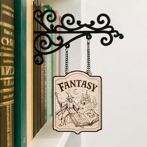 以下が含まれることがあります： ファンタジーの文字と、魔法使い、城、本が描かれたイラストが特徴の木製サイン。 黒い金属製のブラケットに吊り下げられており、装飾的な渦巻き模様が施されています。 チェーンで吊り下げられています。