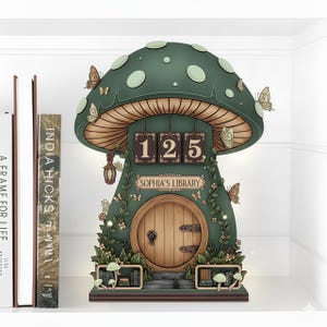 以下が含まれることがあります： 木製のドアと「SOPHIA'S LIBRARY」の文字が付いた、気まぐれな緑色のキノコ型の本棚。キノコの帽子には白い水玉模様があり、蝶が飾られています。番号「125」がドアの上に表示されています。本棚は白い棚にあります。