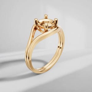 May include: A polished yellow gold ring setting featuring a four-prong head designed to hold a single gemstone. The band has a smooth, continuous bypass-style design that curves upward to meet the central mounting, creating a sleek, open profile.