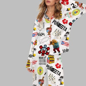 Puede incluir: Conjunto de pijama blanco con un estampado vibrante con s&iacute;mbolos culturales puertorrique&ntilde;os. El dise&ntilde;o incluye la bandera de Puerto Rico, domin&oacute;s, flores y las palabras "Made in Puerto Rico" y "Pu&ntilde;eta".