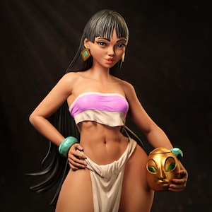 May include: A sculpted figure of a woman with long black hair, wearing a pink and white strapless top and a white skirt. She holds a gold mask with green eyes. She wears turquoise bracelets and earrings. The figure has a tan complexion.