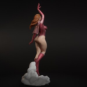 May include: A figurine of a woman in a pink bodysuit and boots, with her right arm raised. Her auburn hair flows behind her. She stands on a cloud-like base, with a dark background.