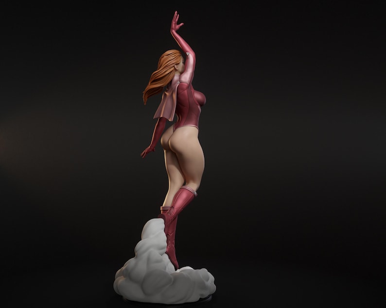 May include: A figurine of a woman in a pink bodysuit and boots, with her right arm raised. Her auburn hair flows behind her. She stands on a cloud-like base, with a dark background.