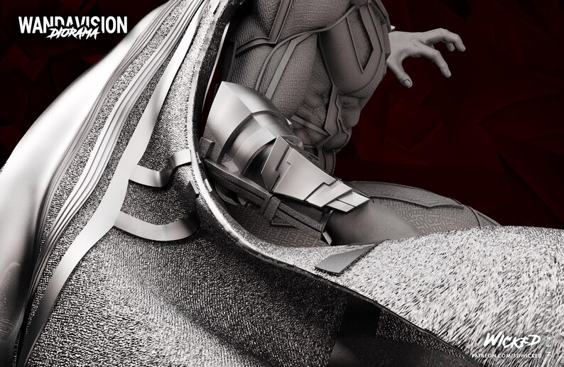 May include: A grayscale diorama figure with the text "WandaVision Diorama" in the upper left corner. The figure has a metallic silver and grey colour scheme, with intricate details on the armour and cape. The figure's arm is outstretched, and the background is a dark red.