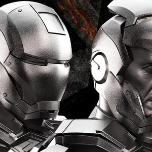May include: Two silver-colored Iron Man helmets are displayed, one complete and the other with the face exposed. The image has the text "AVENGERS ASSEMBLE" in the upper left corner. The background is dark.