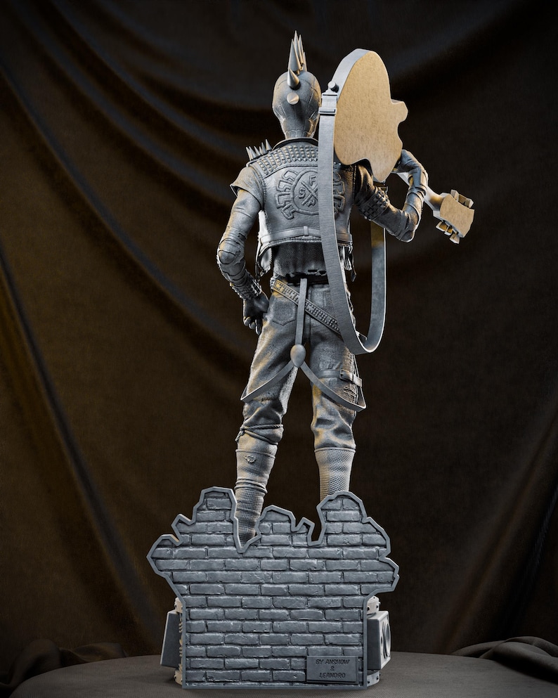 May include: A gray sculpture of a figure with a mohawk and a guitar, standing on a brick wall base. The figure wears a jacket with spikes and holds the guitar over its shoulder. The sculpture is detailed and has a punk rock aesthetic.